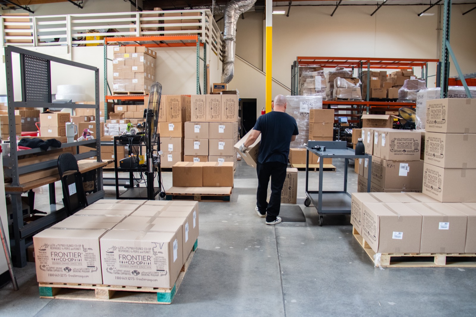 A TESMO crew member moving inventory on the floor